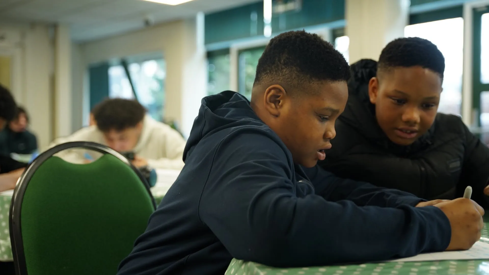 Two young people working together on a piece of writing